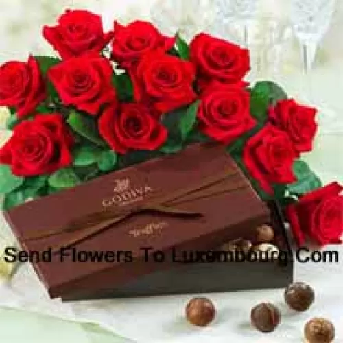 Een prachtige bos van 11 rode rozen met seizoensgebonden opvullers vergezeld van een geïmporteerde doos bonbons
