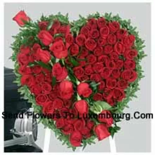 Kaunis sydämen muotoinen asetelma, jossa on 101 punaista ruusua