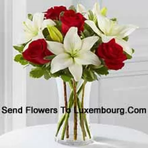 ガラスの花瓶に赤いバラと白い百合、季節の花で飾ったアレンジメント